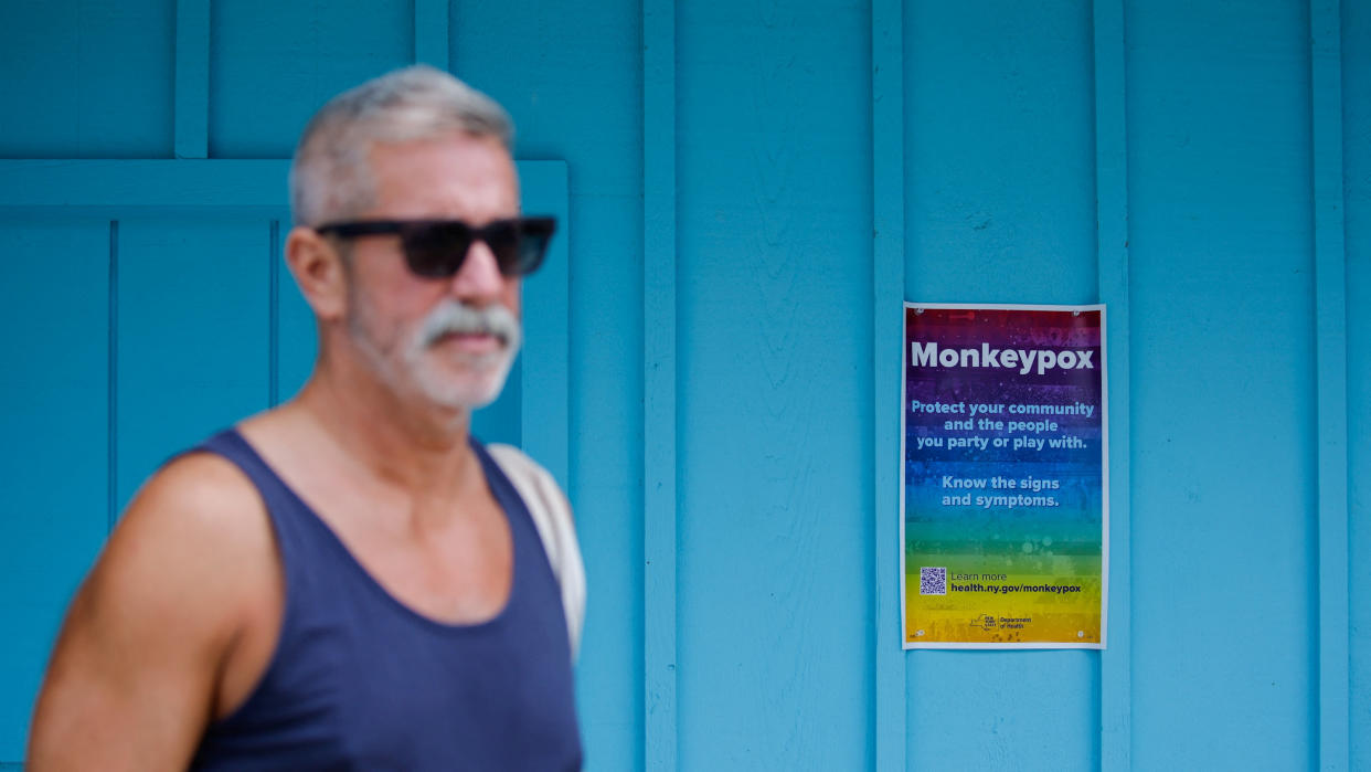 A man walks near a poster with monkeypox information at a local store at Fire Island-Cherry Grove, in New York, U.S., July 15, 2022. REUTERS/Eduardo Munoz