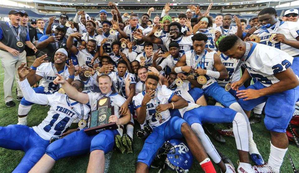 Trinity Christian celebrates with the trophy after defeating American Heritage 30-3 in the FHSAA Class 3A high school football state championship at the Citrus Bowl on Dec. 5, 2015.