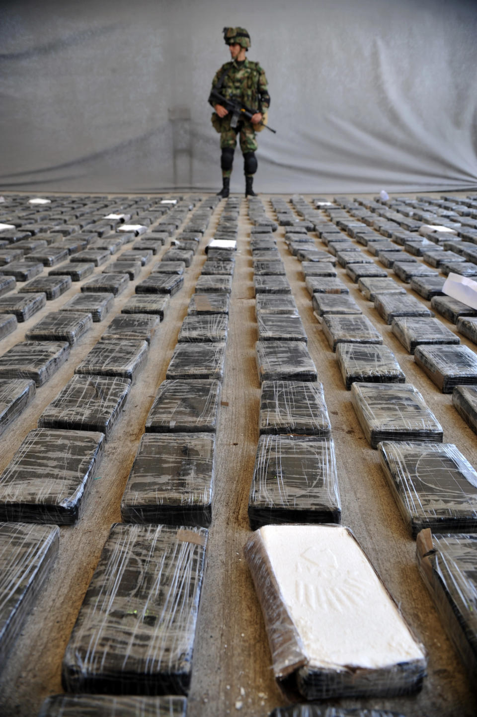 COLOMBIE, Tumaco. Un soldat surveille une cargaison de 3,9 tonnes de cocaïne saisie dans un grand laboratoire clandestin lors de sa présentation à la presse, le 16 mars 2013. AFP/Guillermo Legaria