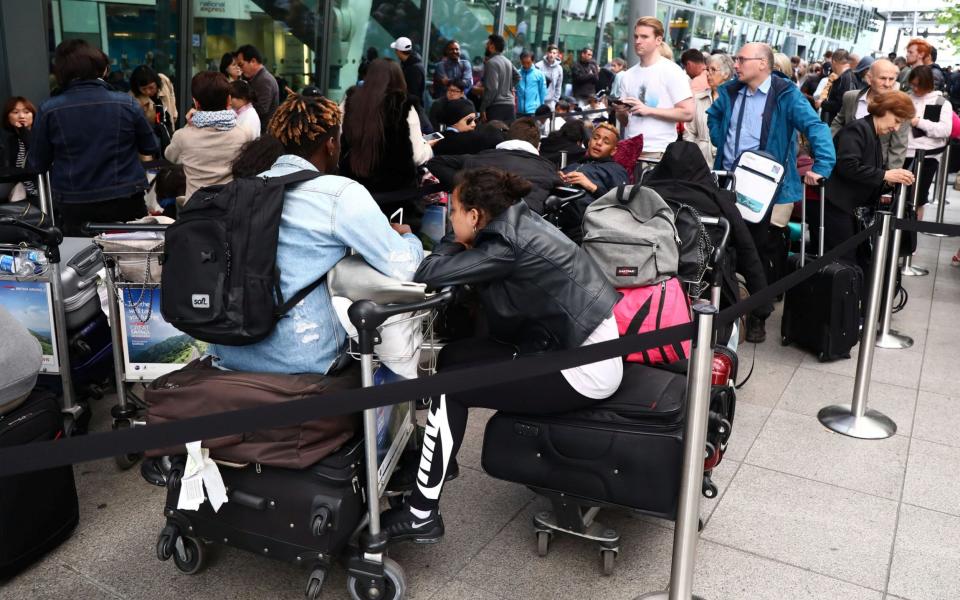 People queue with their luggage outside Heathrow Terminal 5 in London - Credit: Reuters