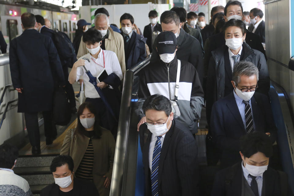 People wearing face masks to protect against the spread of the coronavirus arrive at the train station in Tokyo, Wednesday, Nov. 25, 2020. (AP Photo/Koji Sasahara)