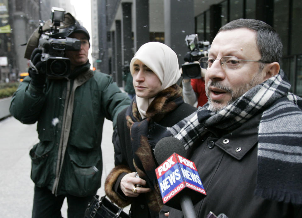 FILE - In this Feb. 1, 2007 file photo, Abdelhaleem Ashqar is surrounded by cameramen as he leaves federal court with his wife, in Chicago. Ashquar who says he fears torture at the hands of Israeli authorities, is back in the U.S. after a judge's order forced immigration authorities to reverse his deportation and bring him back from Israel before he ever got off the plane. According to court papers and interviews, U.S. authorities arrested and deported Ashqar Tuesday, June 4, 2019 after misleading him about his need to report to an immigration office to process paperwork. (AP Photo/Charles Rex Arbogast)