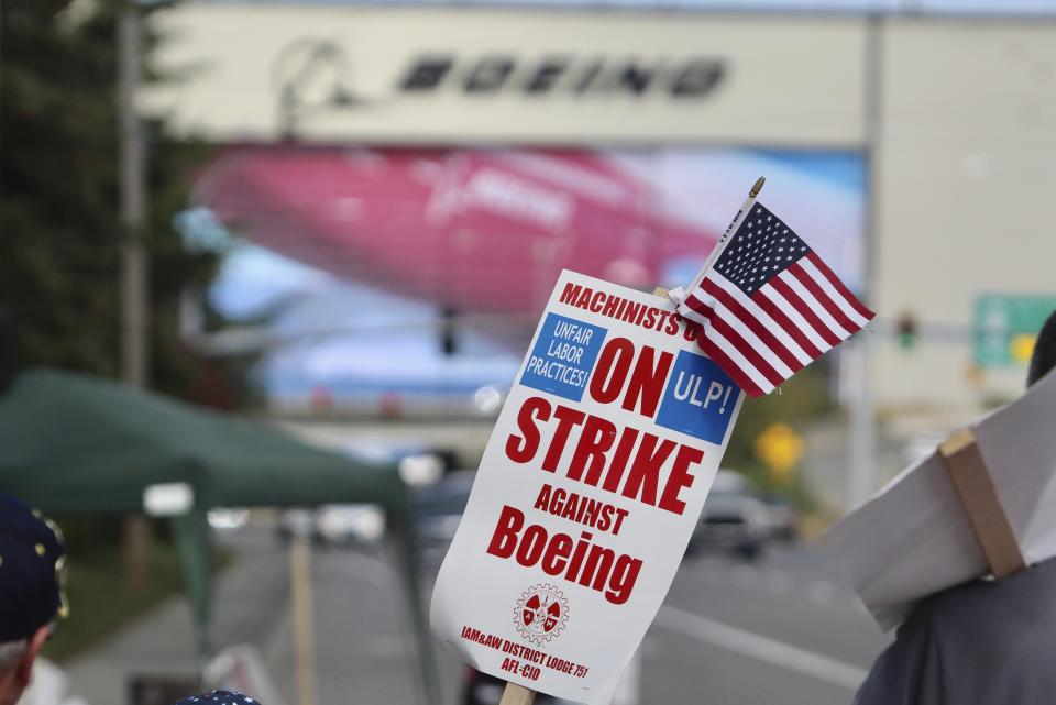 A strike sign is waved on the union machinist picket line near Boeing's factory in Everett, Washington, Thursday, Sept. 19, 2024. (AP Photo/Manuel Valdes)