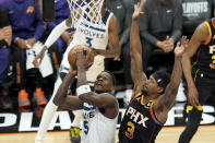 Minnesota Timberwolves guard Anthony Edwards (5) tries to get off a shot as Phoenix Suns guard Bradley Beal (3) defends during the first half of Game 4 of an NBA basketball first-round playoff series, Sunday, April 28, 2024, in Phoenix. (AP Photo/Ross D. Franklin)