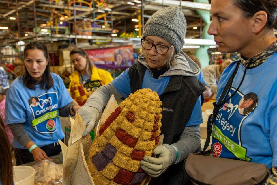 A family works on the Donate Life float 'One Legacy' at Fiesta Parade Floats in Irwindale.