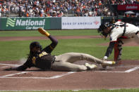 San Diego Padres' Fernando Tatis Jr., left, slides safely home ahead of the tag by San Francisco Giants catcher Patrick Bailey on a double by Jake Cronenworth during the first inning of a baseball game, Sunday, April 7, 2024, in San Francisco. (AP Photo/D. Ross Cameron)