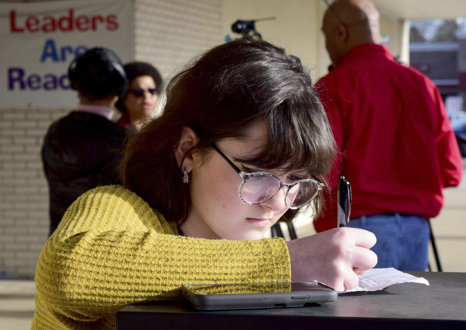 McMinn County student Emma Stratton works on her comments before the McMinn County Neighbors press conference before the school board meeting, Thursday, Feb. 10, 2022, in Athens, Tenn. The McMinn County School Board heard from concerned citizens about the removal of the Pulitzer Prize-winning graphic novel about the Holocaust "Maus," from the district's curriculum at their board meeting on Thursday. (Robin Rudd/Chattanooga Times Free Press via AP)