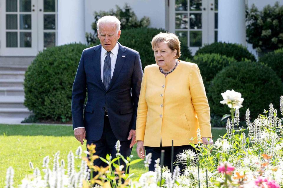 <p>Guido Bergmann/Bundesregierung via Getty</p> President Joe Biden walks on the White House grounds with then-German Chancellor Angela Merkel on July 15, 2021