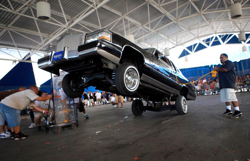 Alex Ortiz bounces a 1983 Cadillac Coupe de Ville owned by Jimmy Garcia at a lowrider bouncing competition held at Mexican Fiesta in 2010.
