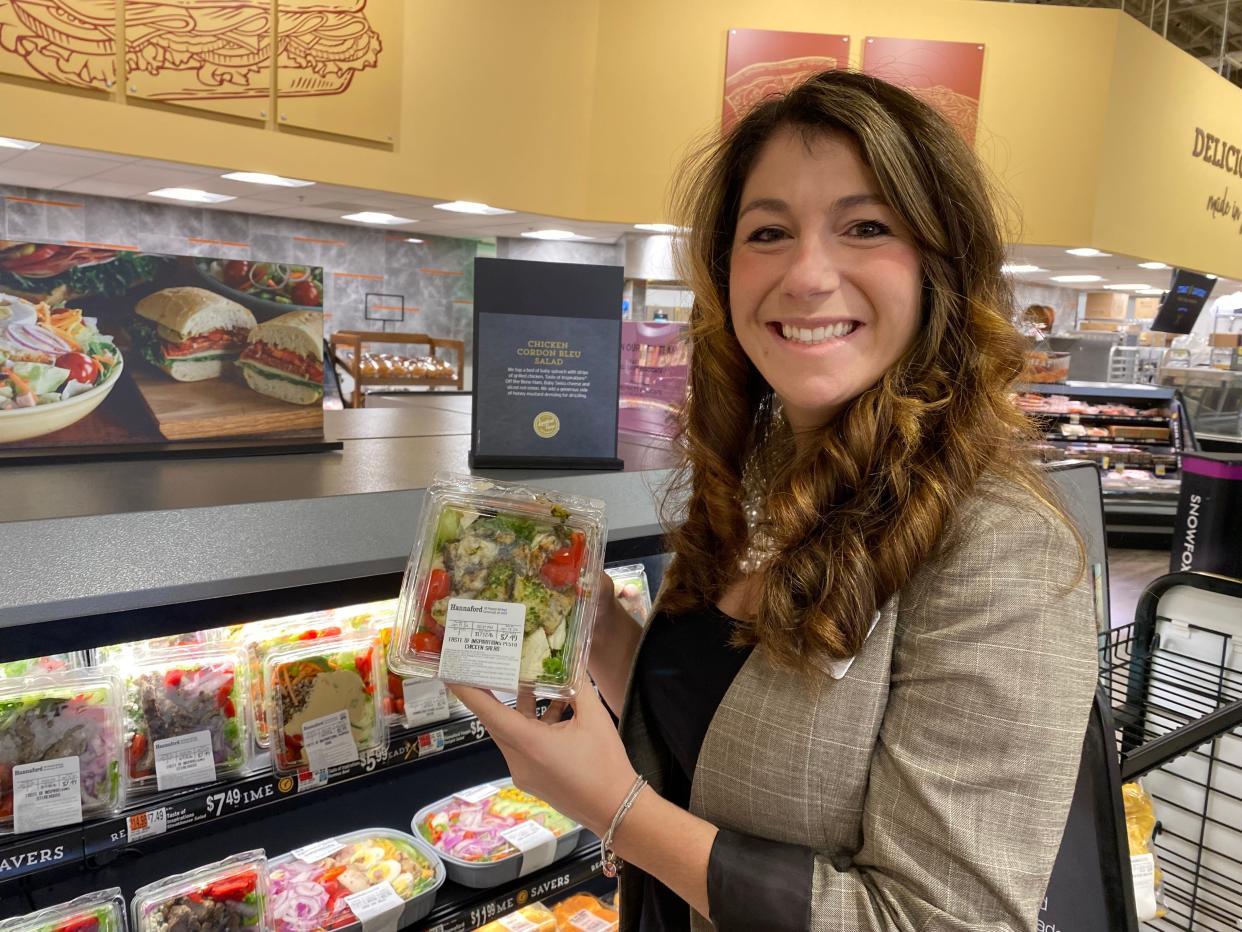 Andrea Nickerson, director of retail operations in the Northeast for Hannaford Supermarket, picks out her favorite salads on Jan. 12, 2024, from one of the new grab and go pre-made meals display cases installed in the store in 2023 during a major renovation.