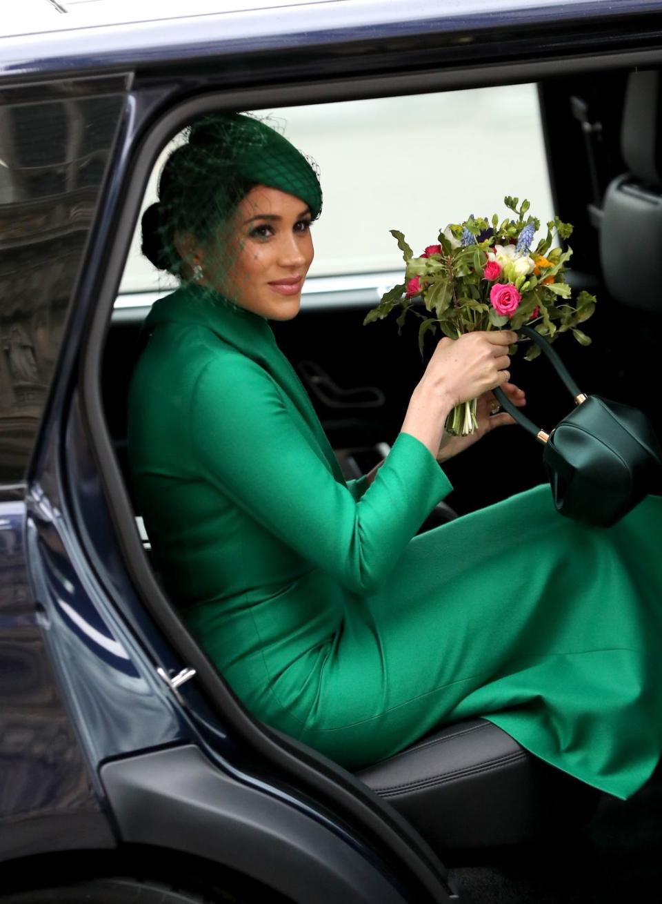 <p>Meghan enters the car with a bouquet of flowers after the Commonwealth Day service. </p>