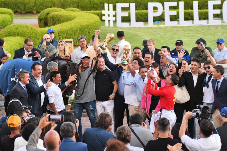 La celebración de todo el equipo de The Punisher, con el jockey Martín Valle alzando a su hija y otros, con las réplicas de la copa del mundo