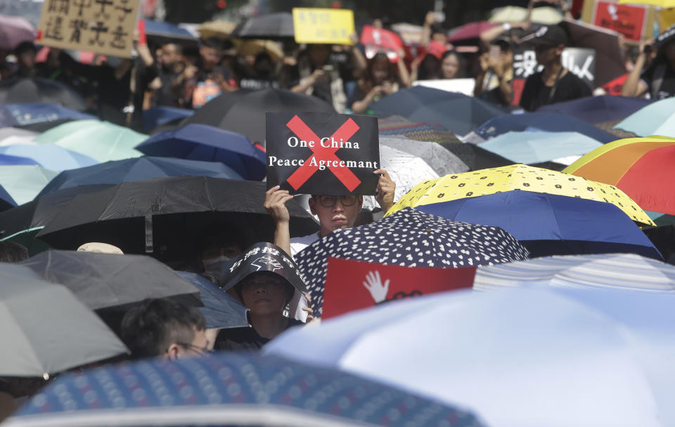 A supporter holds a slogan to oppose the Hong Kong extradition law outside of the Legislative Yuan in Taipei, Taiwan, Sunday, June 16, 2019. Hong Kong residents Sunday continued their massive protest over an unpopular extradition bill that has highlighted the territory's apprehension about relations with mainland China, a week after the crisis brought as many as 1 million into the streets. (AP Photo/Chiang Ying-ying)