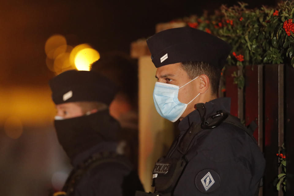 French police officers stand outside a high school after a history teacher who opened a discussion with students on caricatures of Islam's Prophet Muhammad was beheaded, Friday, Oct. 16, 2020 in Conflans-Sainte-Honorine, north of Paris. Police have shot the suspected killer dead. The teacher had received threats after opening a discussion "for a debate" about the caricatures about 10 days ago, the police official told The Associated Press. (AP Photo/Michel Euler)