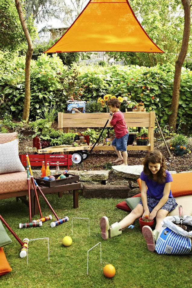 This publicity photo provided by Brian Patrick Flynn shows an excellent way to help control harsh sunlight in an outdoor space by using a shade sail. Designer Brian Patrick Flynn for Hayneedle.com made this Los Angeles backyard a bit more kid-friendly by covering a portion of it with a bold orange shade sail which is suspended with turnbuckles and rope to three nearby trees. The popular product is made from the same weather-proof cloth used on sailboats, and can instantly add shade to an outdoor area. (AP Photo/Brian Patrick Flynn, Daniel J. Collopy)