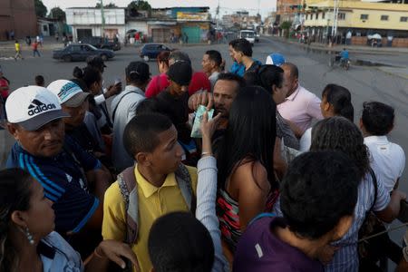 A commuter pays for a ride on a cargo truck used as public transportation in Valencia, Venezuela July 12, 2018. REUTERS/Marco Bello