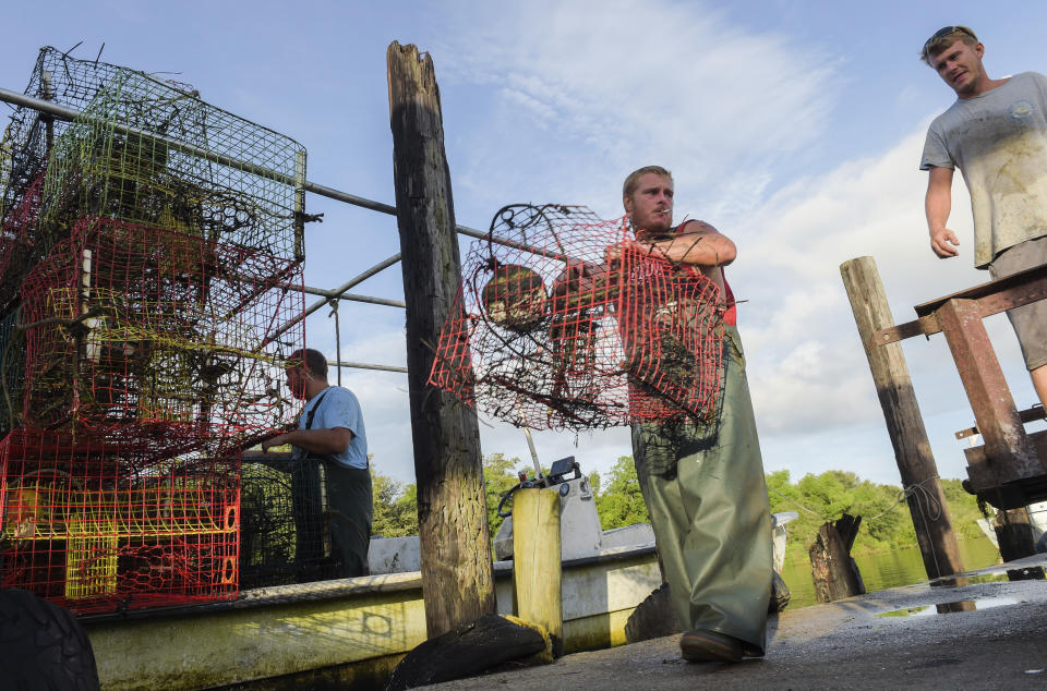 Commercial crabbers Derek Grose, right, Joe Becker, center, and Patrick Nata collect crab traps before the flood wall closes as Hurricane Ida approaches the Louisiana coast in St. Bernard, La. Saturday, Aug. 28, 2021. Residents across Louisiana’s coast rushed to prepare for the approach of an intensifying Hurricane Ida. The storm is expected to bring winds as high as 140 mph when it slams ashore late Sunday.( Max Becherer, NOLA.com, The Times-Picayune/The New Orleans Advocate via AP)