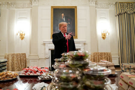 U.S. President Donald Trump speaks in front of fast food provided for the 2018 College Football Playoff National Champion Clemson Tigers due to the partial government shutdown in the State Dining Room of the White House in Washington, U.S., January 14, 2019. REUTERS/Joshua Roberts