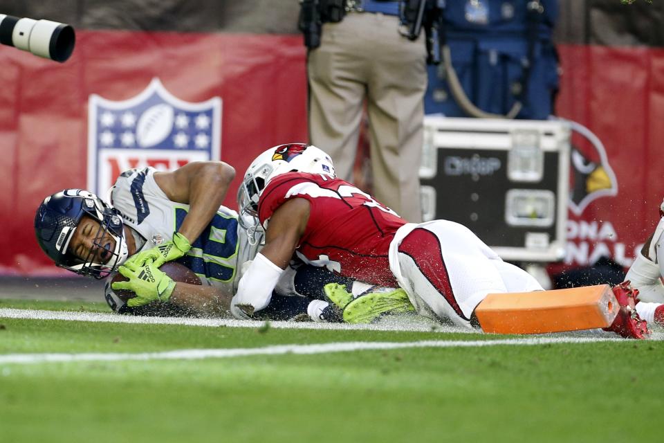 Seattle Seahawks wide receiver Tyler Lockett, left, scores a touchdown as Arizona Cardinals free safety Jalen Thompson, right, makes a late tackle during the first half of an NFL football game Sunday, Jan. 9, 2022, in Glendale, Ariz. (AP Photo/Ralph Freso)