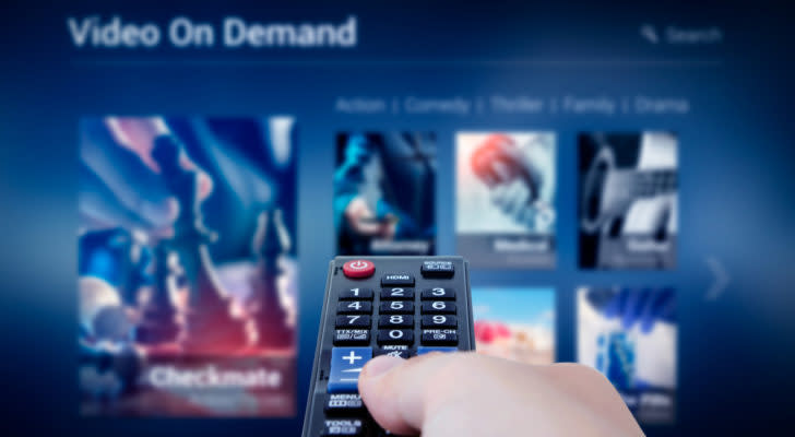 a person holing a remote control pointed at a tv