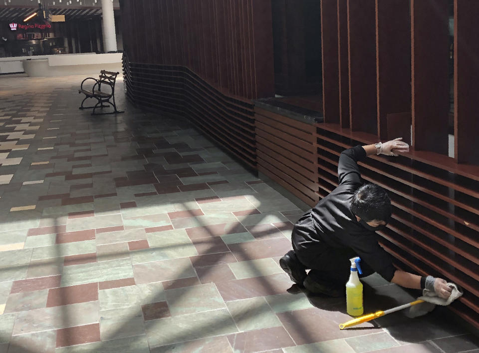 In this May 22, 2020 photo, a maintenance employee cleans some of the woodwork at Foxwoods Resort Casino in Mashantucket, Conn., as part of the casino's stepped up cleaning regimen in advance of a planned partial reopening on June 1. Both the tribal-owned Foxwoods and Mohegan Sun are pushing ahead with plans to open parts of their resorts on tribal lands, despite opposition from Connecticut Gov. Ned Lamont. Foxwoods officials say only 25% of the sprawling resort will be reopened initially. (AP Photo/Susan Haigh)