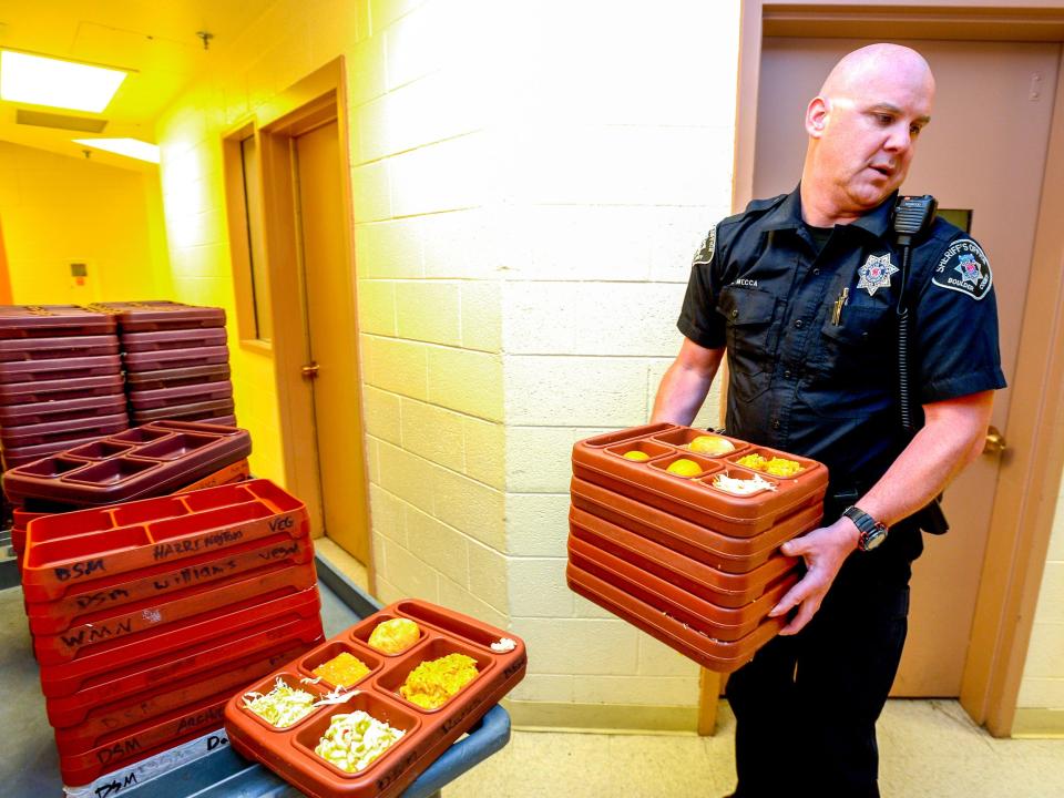 Boulder County Sheriff's Deputy C. Mecca prepares meals for inmates lunch time in the maximum security area at the Boulder County Jail on Monday June 2, 2014. For more photos and video from the jail go to www.dailycamera.com. (Photo by Paul Aiken/Digital First Media/Boulder Daily Camera via Getty Images)