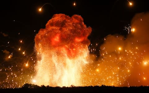A powerful explosion is seen in the ammunition depot at a military base in Kalynivka - Credit: AP