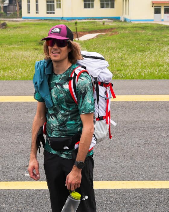 Ziemski at an airport strip, with cap, t-shirt and sunglasses