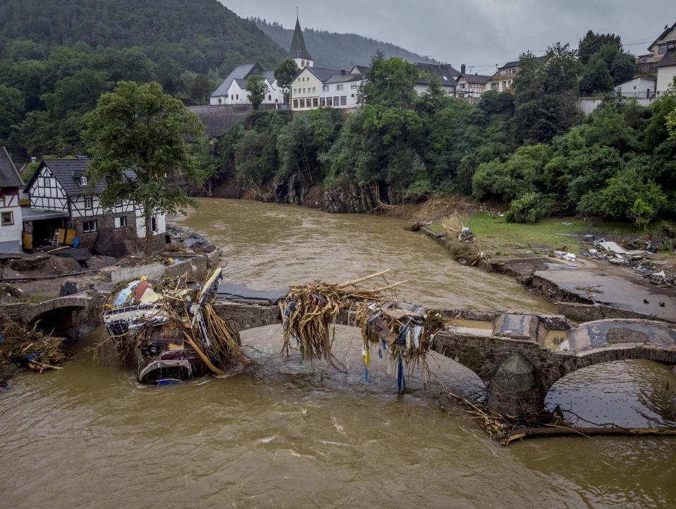 FOR HOLD -FILE - In this Friday, July 16, 2021, file photo, debris hangs on a damaged bridge over the Ahr river in Schuld, Germany after massive floods in the region. Germany's parliament last week approved a 30 billion-Euro, 35 billion Dollars, rebuilding fund for the swath of western Germany affected by the flooding. Overseeing that long-term effort will fall to Germany's next administration. (AP Photo/Michael Probst, File)