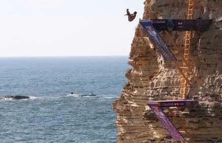 A diver jumps off a cliff during the Red Bull Cliff Diving World Series at the Raouche rock in Beirut