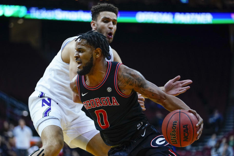 Georgia's Jailyn Ingram, right, drives past Northwestern's Pete Nance during the first half of an NCAA college basketball game Tuesday, Nov. 23, 2021, in Newark, N.J. (AP Photo/Frank Franklin II)