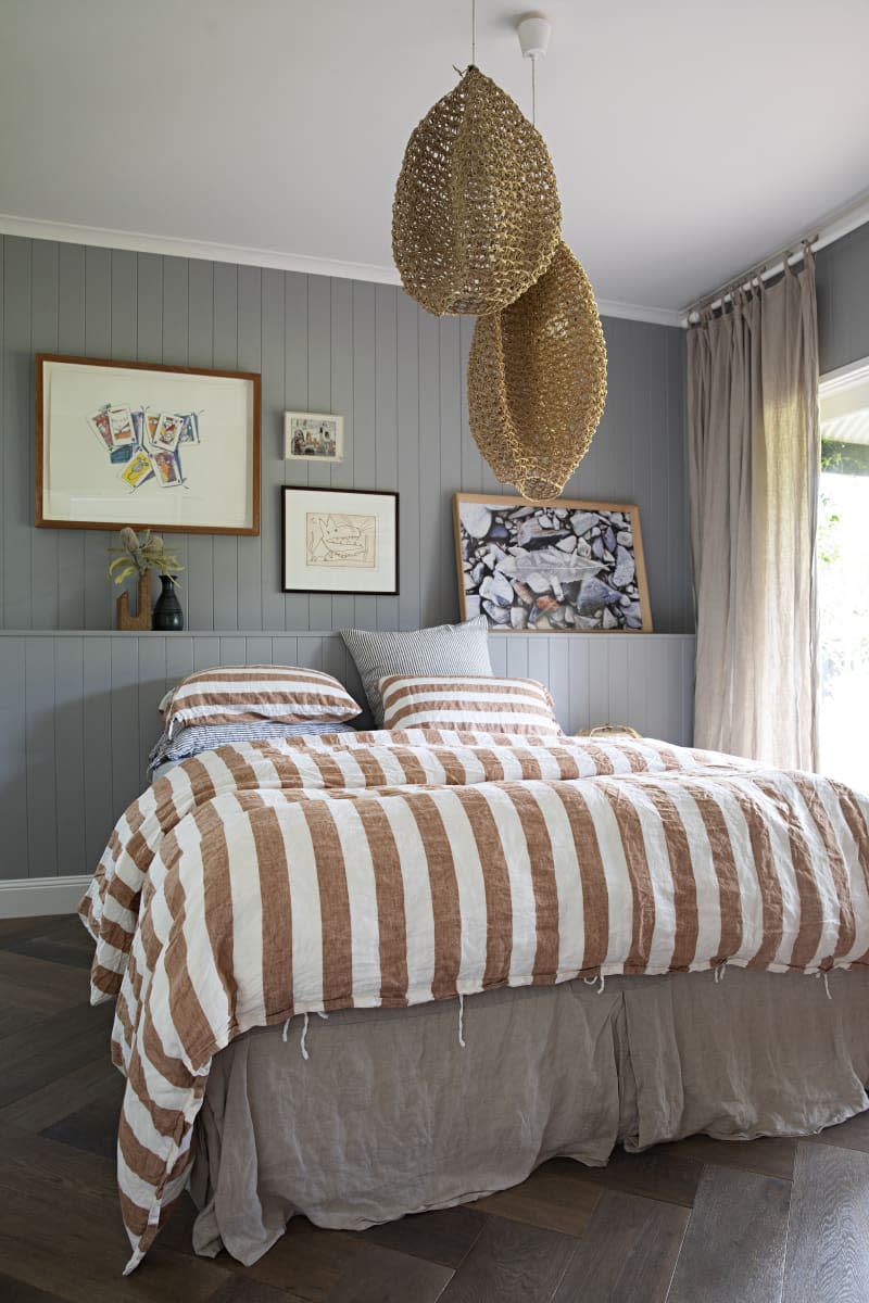 a pale gray bedroom with a white and orange bedspread