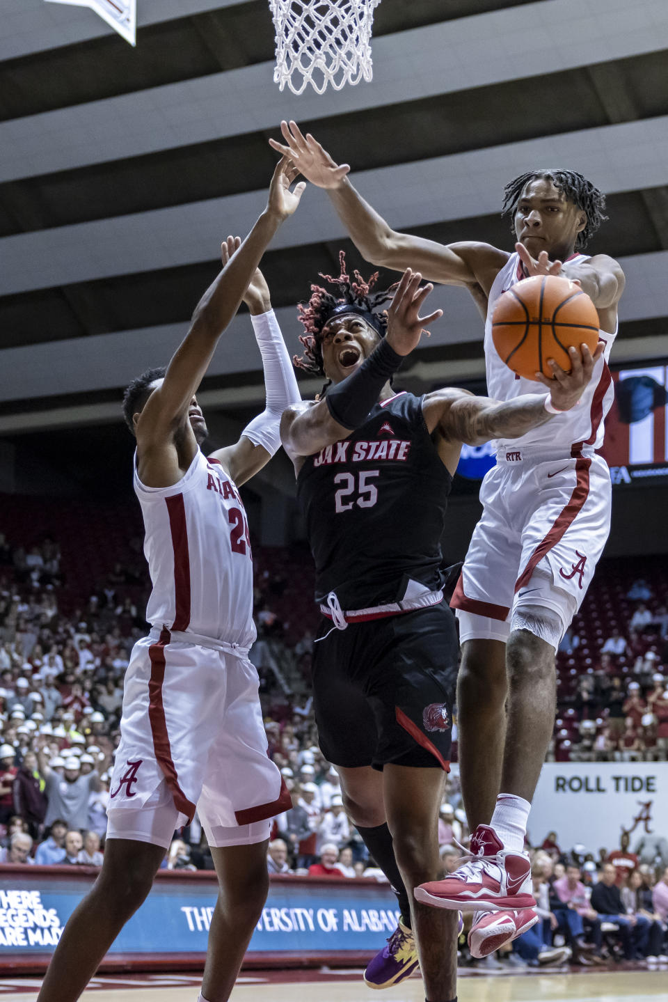 Alabama forward Brandon Miller, left, Jacksonville State forward Clarence "Monzy" Jackson (25) and Alabama forward Noah Clowney, right, chase a rebound during the first half of an NCAA college basketball game, Friday, Nov. 18, 2022, in Tuscaloosa, Ala. (AP Photo/Vasha Hunt)