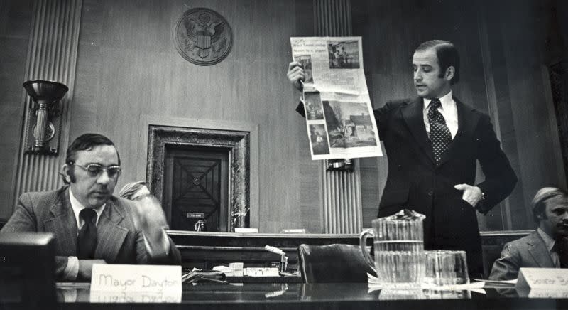 Sen. Joe Biden shows federal housing officials a newspaper page showing poor living conditions in West Laurel. Biden was fighting for federal funds for urban renewal efforts in the town. Feb. 22, 1973.