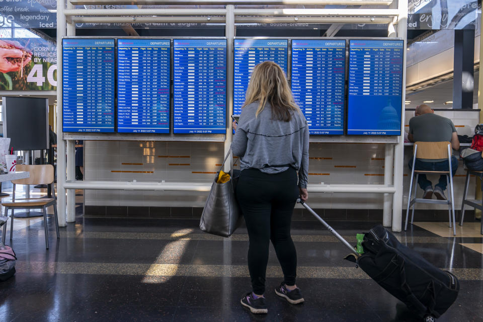 A traveler checks her flight status at Ronald Reagan Washington National Airport.