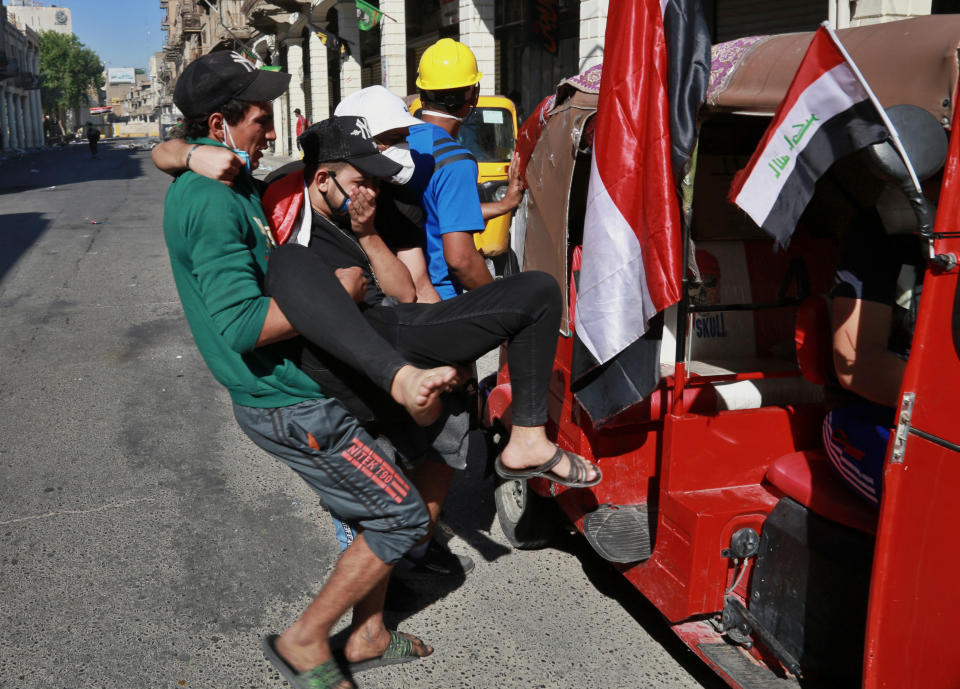 An injured protester is rushed to a hospital during clashes between Iraqi security forces and anti-government protesters in the al-Rasheed street in Baghdad, Iraq, Friday, Nov. 8, 2019. The demonstrators complain of widespread corruption, lack of job opportunities and poor basic services, including regular power cuts despite Iraq's vast oil reserves. They have snubbed limited economic reforms proposed by the government, calling for it to resign. (AP Photo/Khalid Mohammed)