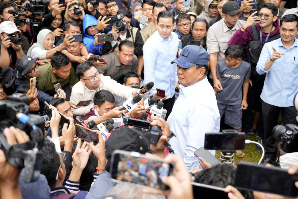 Indonesian presidential candidate Prabowo Subianto, center, talks to the media during the election in Bojong Koneng, Indonesia, Wednesday, Feb. 14, 2024. Indonesian voters were choosing a new president Wednesday as the world's third-largest democracy aspires to become a global economic powerhouse a quarter-century after shaking off a brutal dictatorship. (AP Photo/Vincent Thian)