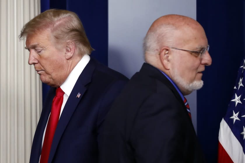 FILE - In this April 22, 2020, file photo President Donald Trump passes Dr. Robert Redfield, director of the Centers for Disease Control and Prevention, during a briefing about the coronavirus in the James Brady Press Briefing Room of the White House in Washington. (AP Photo/Alex Brandon, File)