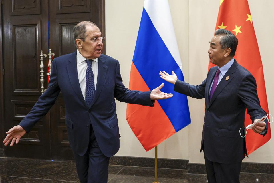 In this handout photo released by Russian Foreign Ministry Press Service, Russian Foreign Minister Sergey Lavrov, left, and Chinese Foreign Minister Wang Yi gesture during their bilateral meeting ahead of the G20 Foreign Ministers' Meeting in Nusa Dua, Bali, Indonesia, Thursday, July 7, 2022. (Russian Foreign Ministry Press Service via AP)
