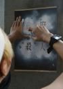 A protester spray paints "government is a murderer" on a pillar outside the Education Ministry in Taipei on July 31, 2015