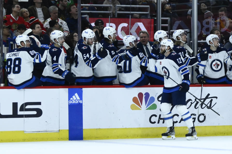 Winnipeg Jets center Jansen Harkins high fives teammates after scoring during the first period of an NHL hockey game against the Chicago Blackhawks, Sunday, Nov. 27, 2022, in Chicago. (AP Photo/Matt Marton)