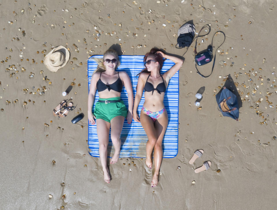 Alex Woolley (left) and Megan Young, both 22 of Cirencester, enjoy the hot weather on Bournemouth beach.