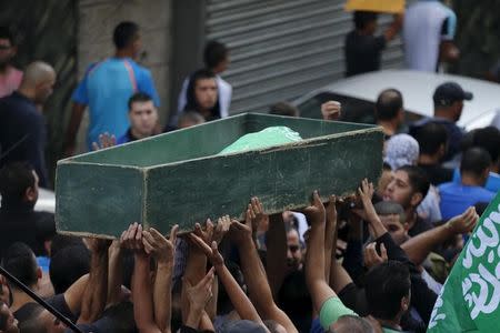 Mourners carry the body of 22-year-old Palestinian Ahmad Qali, who was shot by Israeli troops during late-night clashes, during his funeral in the Palestinian refugee camp of Shuafat near Jerusalem October 10, 2015. REUTERS/Ammar Awad