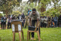 Uganda's leading opposition challenger Bobi Wine fills his ballot before voting in Kampala, Uganda, Thursday, Jan. 14, 2021. Ugandans are voting in a presidential election tainted by widespread violence that some fear could escalate as security forces try to stop supporters of Wine from monitoring polling stations.(AP Photo/Jerome Delay)