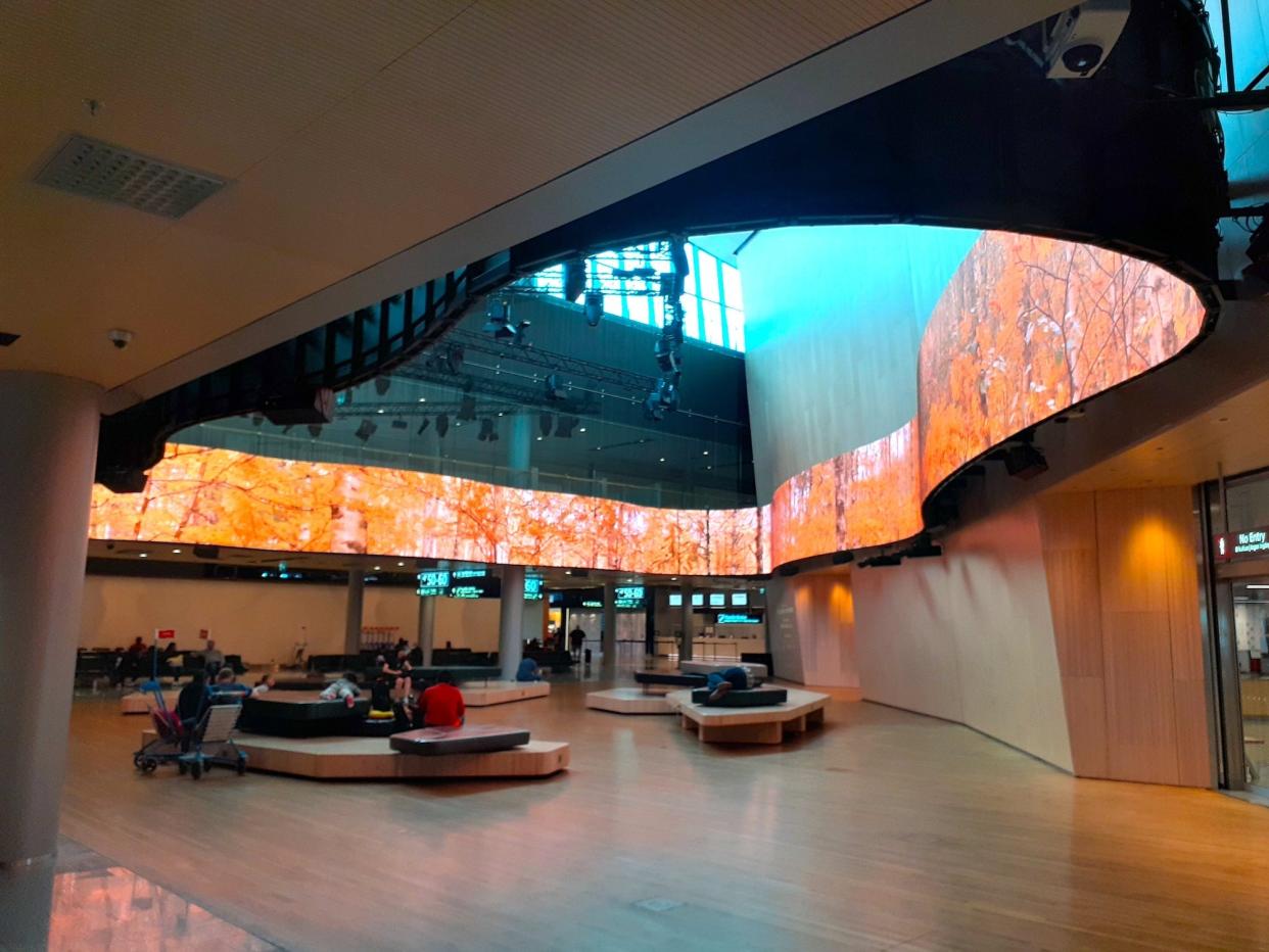 A waiting area with Finnish nature-themed screen wrapping aroudn it is shown.