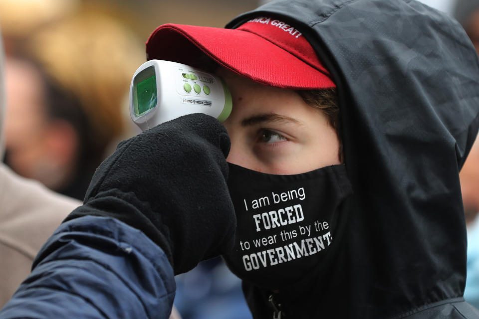 Supporters of President Donald Trump have their temperature taken as a precaution against the coronavirus before attending a campaign rally at Capital Region International Airport Oct. 27 in Lansing, Michigan. (Photo: Chip Somodevilla via Getty Images)