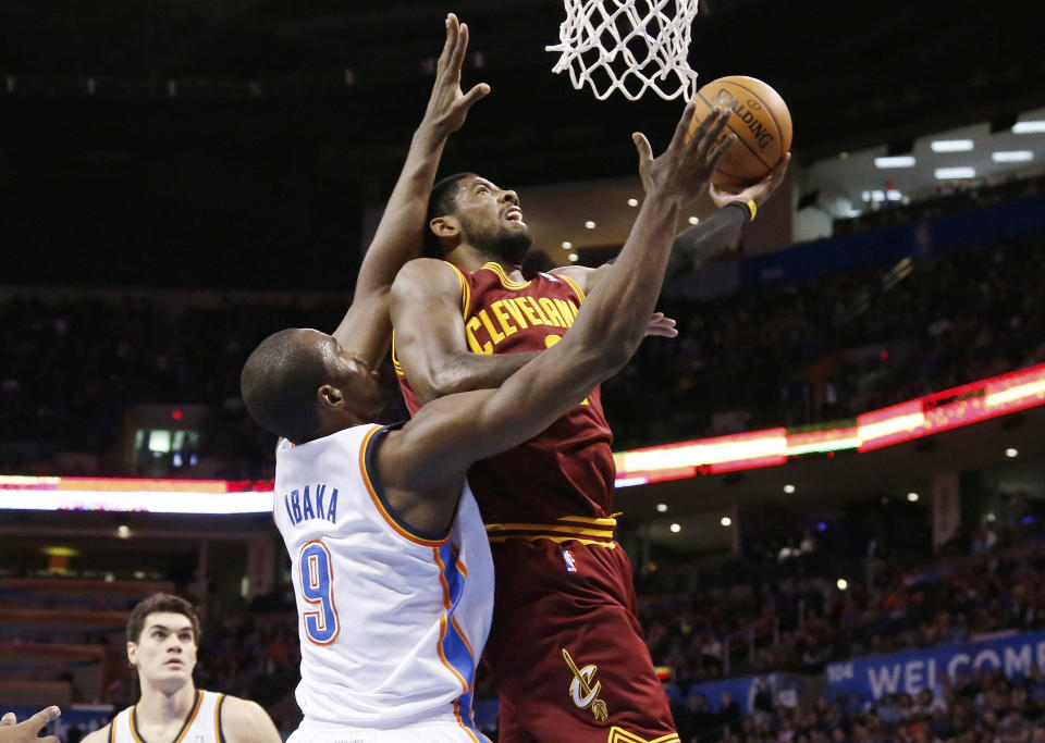 Cleveland Cavaliers guard Kyrie Irving (2) shoots in front of Oklahoma City Thunder forward Serge Ibaka (9) during the second quarter of an NBA basketball game in Oklahoma City, Wednesday, Feb. 26, 2014. (AP Photo/Sue Ogrocki)