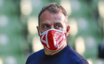 Bayern's head coach Hansi Flick watches behind a Bayern face mask prior the German Bundesliga soccer match between Werder Bremen and Bayern Munich in Bremen, Germany, Tuesday, June 16, 2020. Bayern became champion for the 30th time in Germany after winning the match. Because of the coronavirus outbreak all soccer matches of the German Bundesliga take place without spectators. (AP Photo/Martin Meissner, Pool)