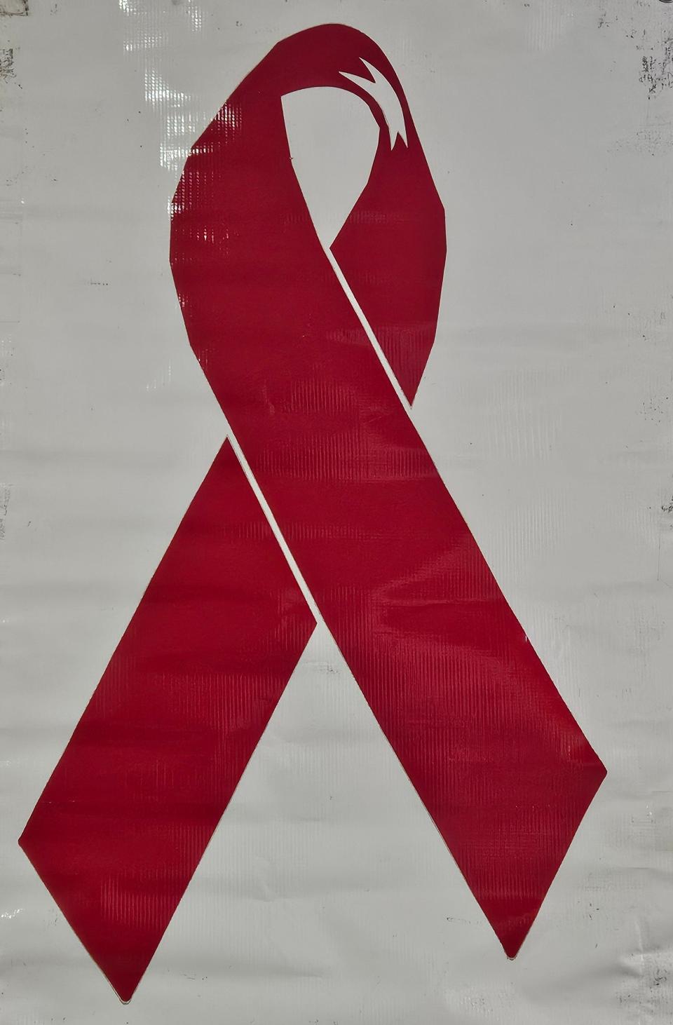 The red ribbon represents raising awareness and supporting those living with HIV.