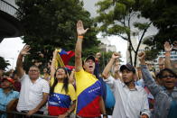 CORRECTS WHY SUPPORTERS ARE RAISING THEIR HANDS - Supporters of opposition leader and self-proclaimed interim president of Venezuela Juan Guaido show their approval after learning that the National Assembly approved Venezuela's return to the Inter-American Treaty of Reciprocal Assistance, at a rally in Caracas, Venezuela, Tuesday, July 23, 2019. (AP Photo/Ariana Cubillos)